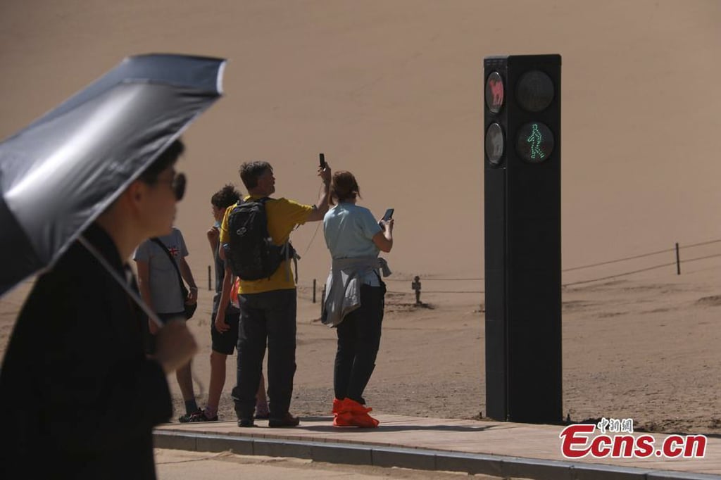 Tourists take photos of the traffic signal for camels. Photo: China News Service