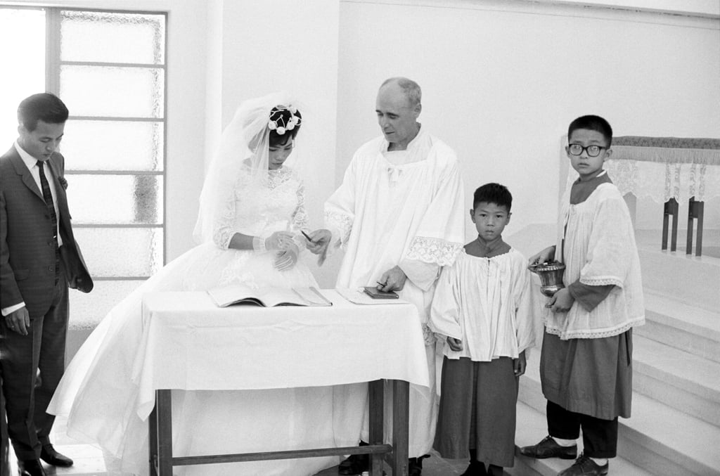 A missionary hands a bride a pen to sign the marriage certificate in 1950s Hong Kong. Photo: Getty Images