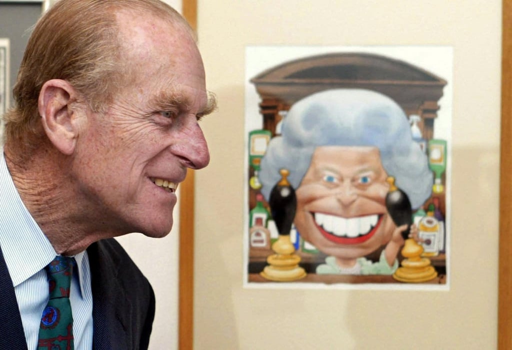 Britain’s Prince Philip, Duke of Edinburgh, stands next to a cartoon of his wife Queen Elizabeth at the Cartoon Art Trust’s Kings and Queens exhibition at the Mall Galleries, London, of which he is a patron, in 2002. Photo: AFP