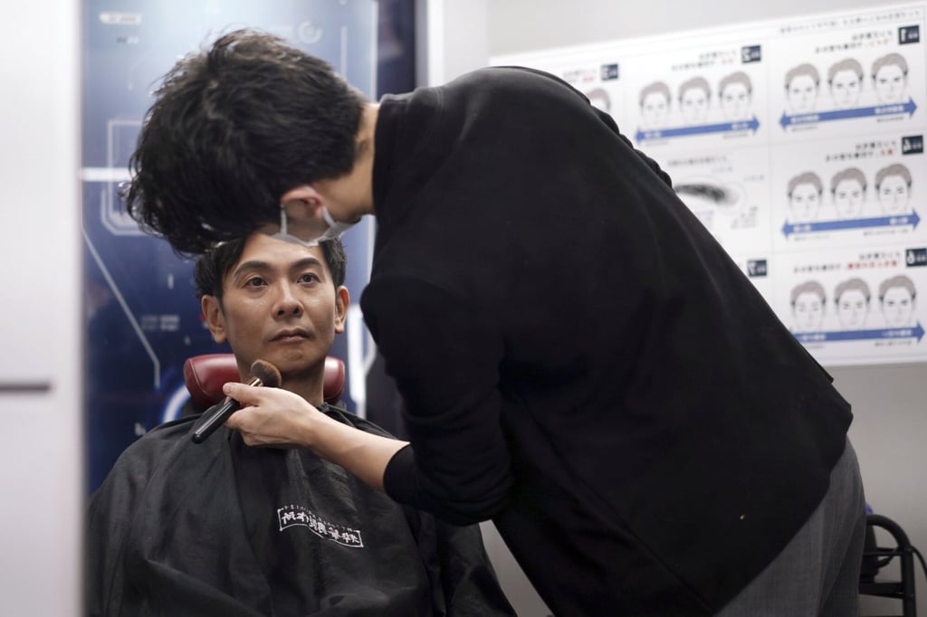 Kamichi receives make-up and gets his hair done by a make-up artist at Ikemen-Works. Photo: AP