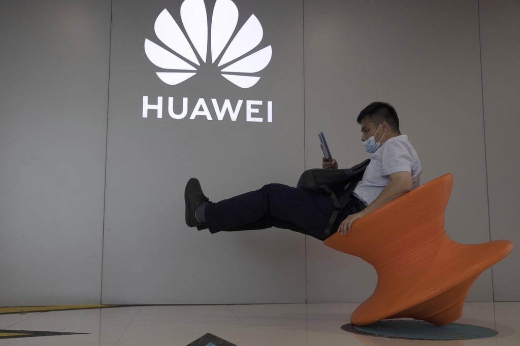 A man sits near a Huawei store in Beijing on July 31, 2020. Photo: AP Photo