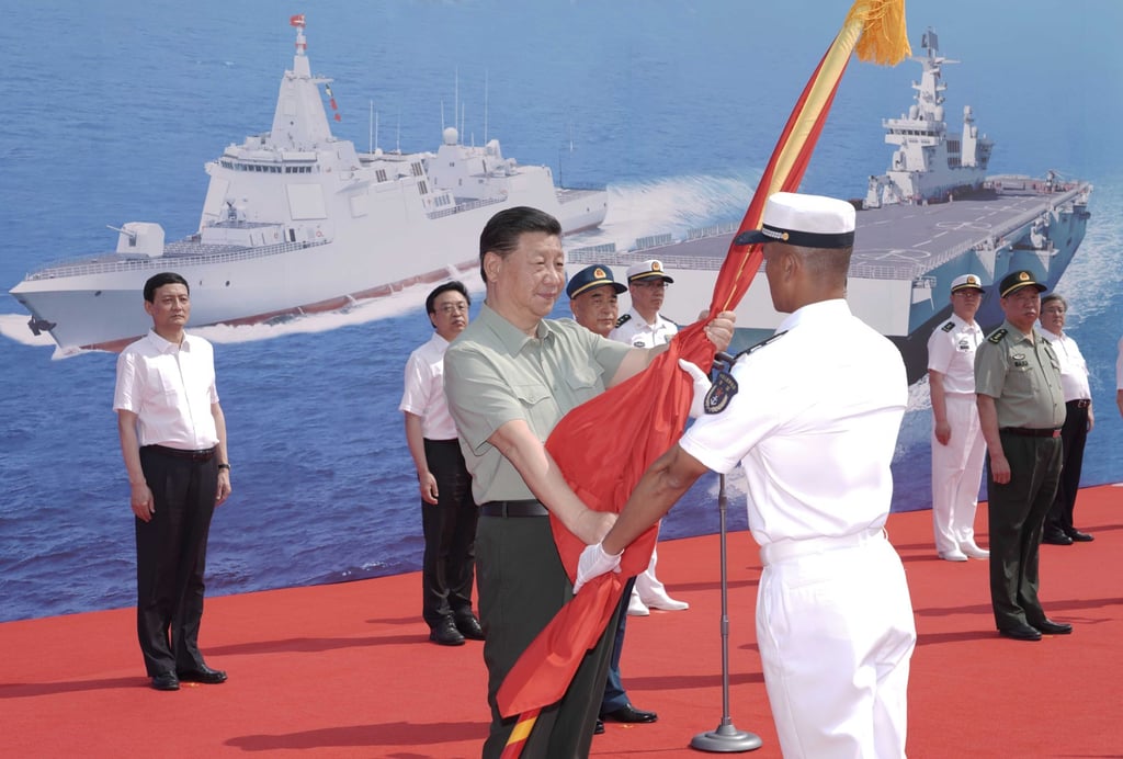 President Xi Jinping presents the PLA flag to the captain of the Long March-18 in Sanya on Friday. Photo: Xinhua
