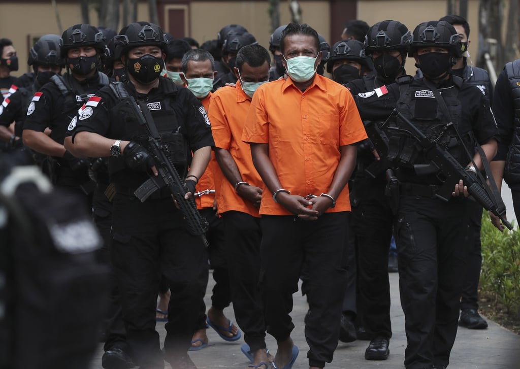Indonesian police escort drug suspects before a news conference in Jakarta on April 28, 2021. Photo: AP