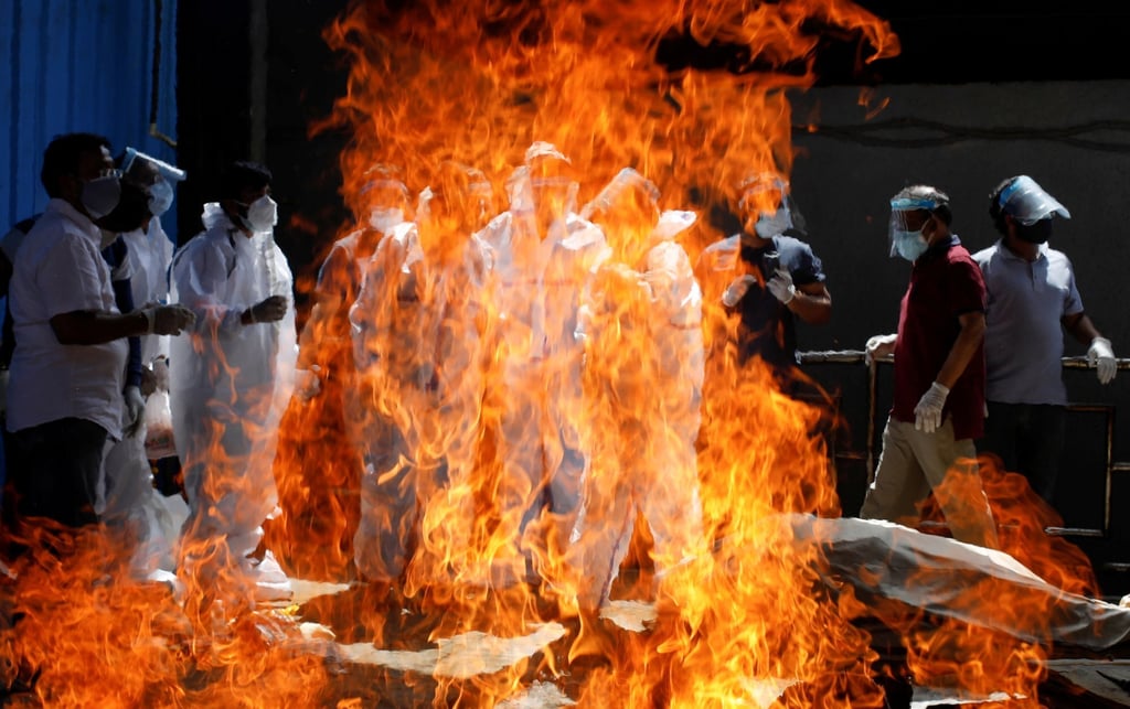Relatives wearing personal protective equipment attend the funeral of a man who died from Covid-19 in New Delhi. Photo: Reuters