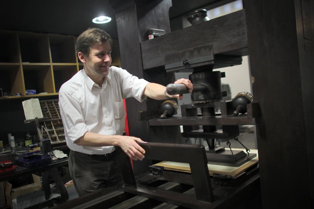 Swiss author Peter Stamm with a printing press at the Gutenberg Museum in Mainz, Germany. Photo: Getty Images
