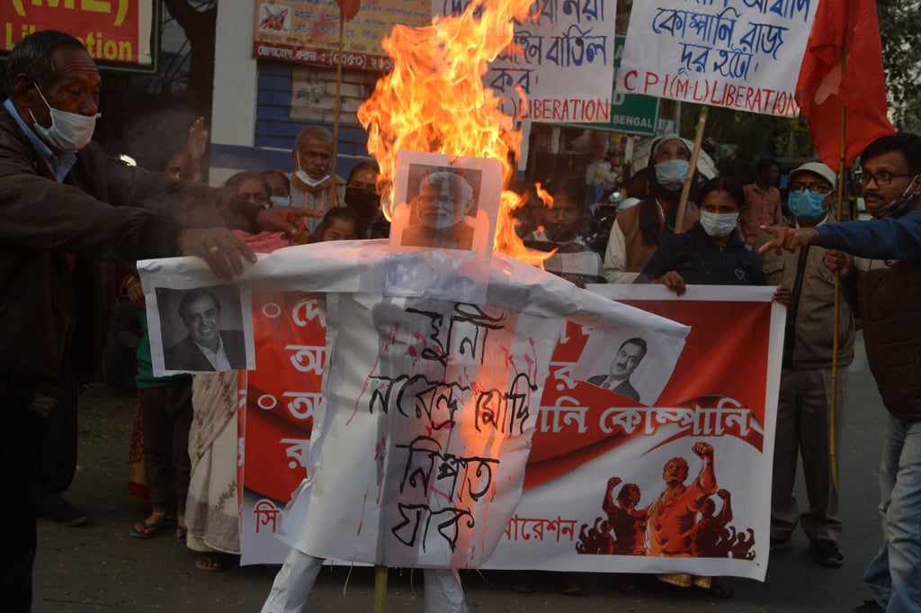 Activists burning effigies of Indian Prime Minister Narendra Modi and Reliance Industries chairman Mukesh Ambani to protest against agricultural reforms in Siliguri in December 2020. Photo: AFP