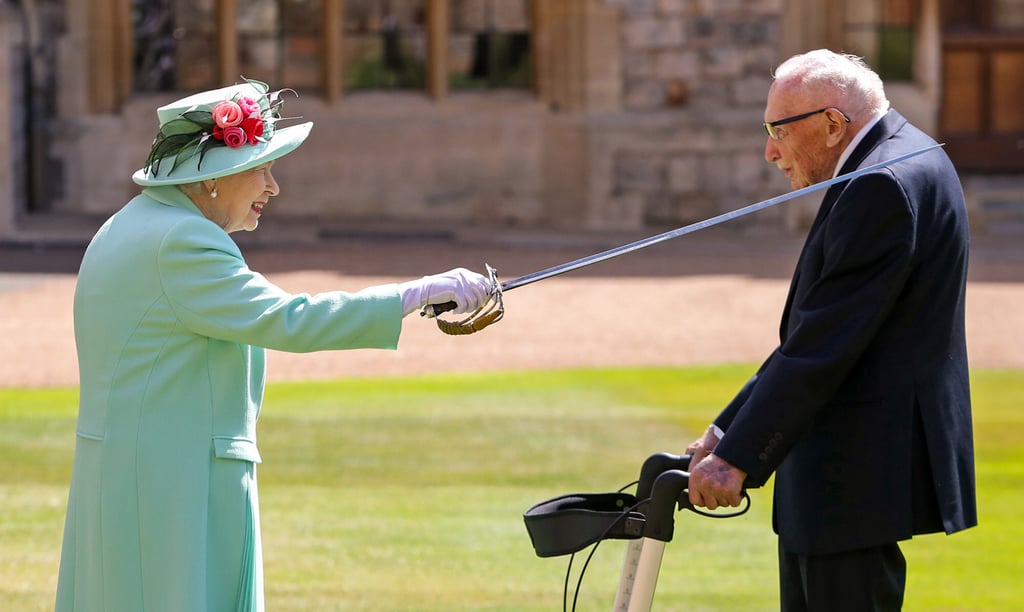 Britain’s Queen Elizabeth uses the sword that belonged to her father, George VI, as she confers the Honour of Knighthood on 100-year-old World War Two veteran Captain Tom Moore at Windsor Castle in Windsor, west of London, in July 2020. Photo: AFP Britain’s Queen Elizabeth uses the sword that belonged to her father, George VI, as she confers the Honour of Knighthood on 100-year-old World War Two veteran Captain Tom Moore at Windsor Castle in Windsor, west of London, in July 2020. Photo: AFP