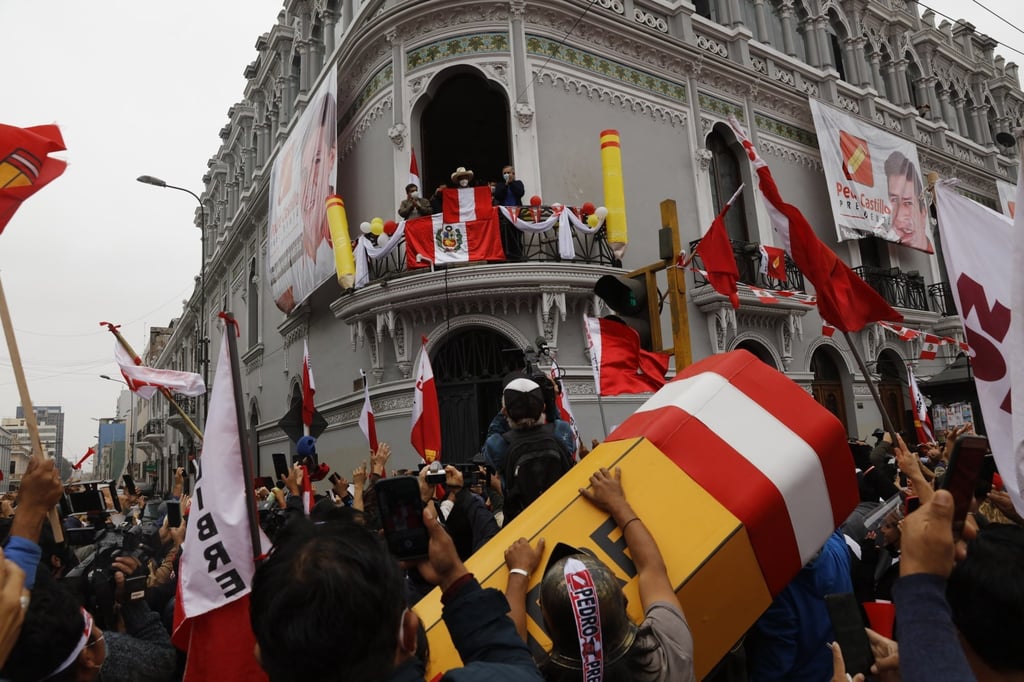 Presidential candidate Pedro Castillo looks out over supporters from the balcony of his campaign headquarters in Lima. Photo: AP Presidential candidate Pedro Castillo looks out over supporters from the balcony of his campaign headquarters in Lima. Photo: AP