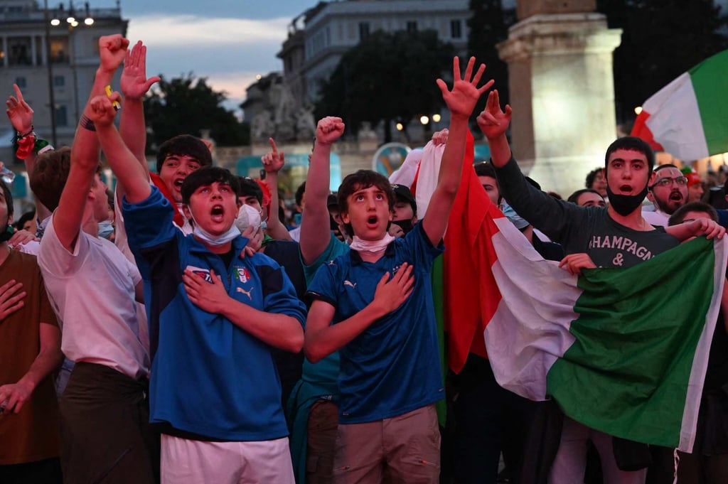 Italy’s fans watch the Euro 2020 on a giant screen from the official fan zone at Piazza del Popolo in Rome on Friday. Photo: AFP