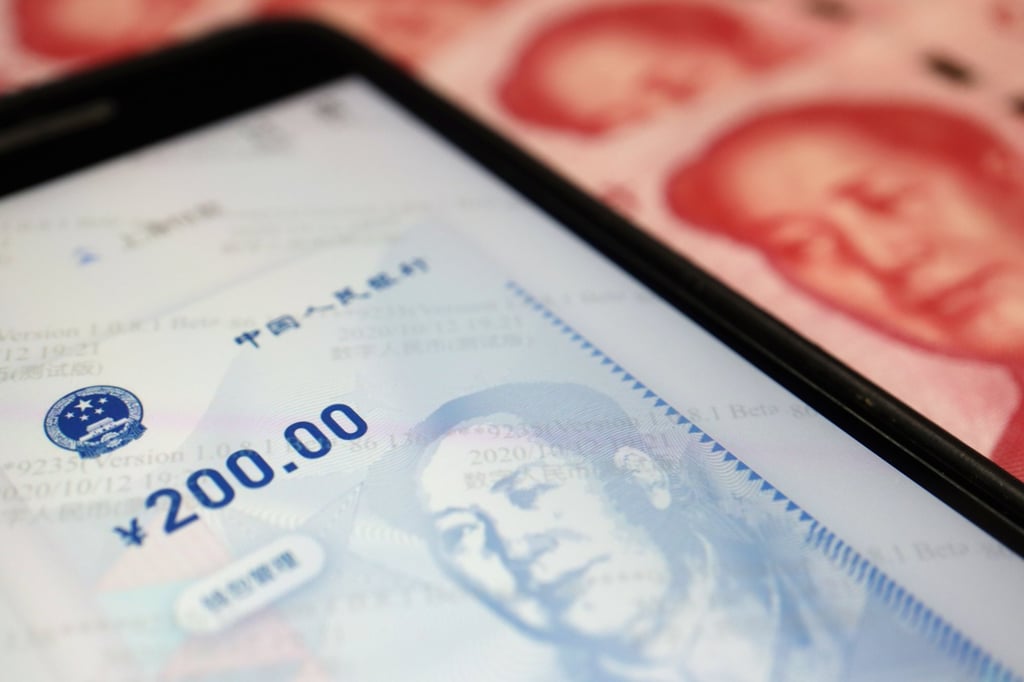 China’s official app for the digital yuan is seen on a mobile phone next to 100-yuan banknotes. Talks are ongoing between the HKMA and PBOC about the use of the digital yuan for cross-border payments. Photo: Reuters