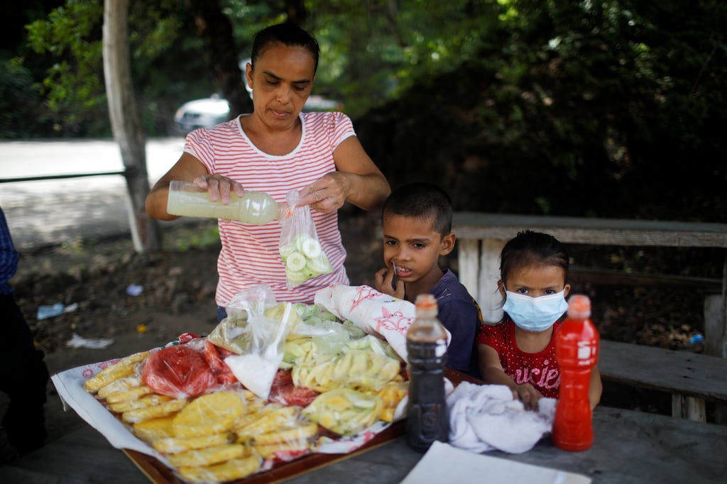 Zulma Rivas sells fruit with her children at El Zonte Beach in Chiltiupan, El Salvador, on June 10. Photo: Reuters