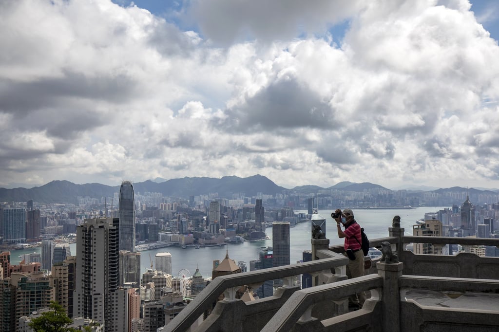 A person takes a photograph of the city’s skyline on a viewing terrace at Victoria Peak in Hong Kong on May 26. The collapse of the tourism industry under the double stresses of the Covid-19 pandemic and sociopolitical unrest has left many bereft of jobs and stable income. Photo: Bloomberg A person takes a photograph of the city’s skyline on a viewing terrace at Victoria Peak in Hong Kong on May 26. The collapse of the tourism industry under the double stresses of the Covid-19 pandemic and sociopolitical unrest has left many bereft of jobs and stable income. Photo: Bloomberg