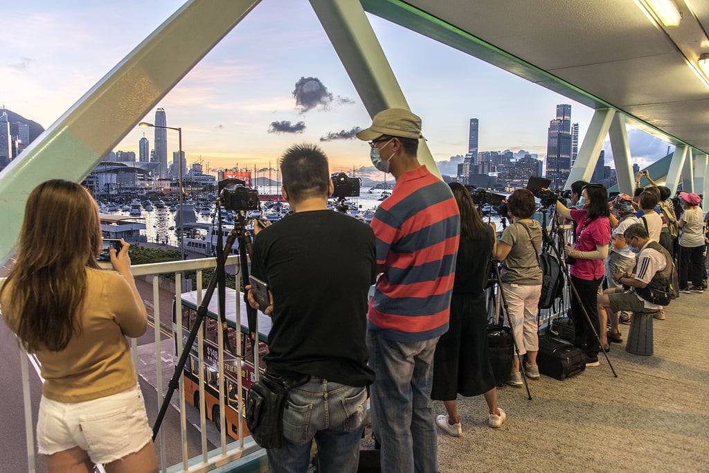 Serious photographers, camera club newbies and a smattering of smartphone snappers gather on a footbridge near the Noon Day Gun in Causeway Bay. Photo: Tim Pile Serious photographers, camera club newbies and a smattering of smartphone snappers gather on a footbridge near the Noon Day Gun in Causeway Bay. Photo: Tim Pile