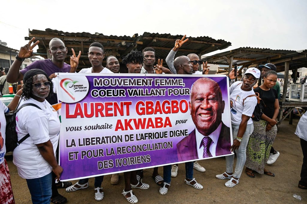 People hold a banner bearing the face of Laurent Gbagbo on June 17, 2021 during a rally ahead of his arrival in Ivory Coast. Photo: AFP