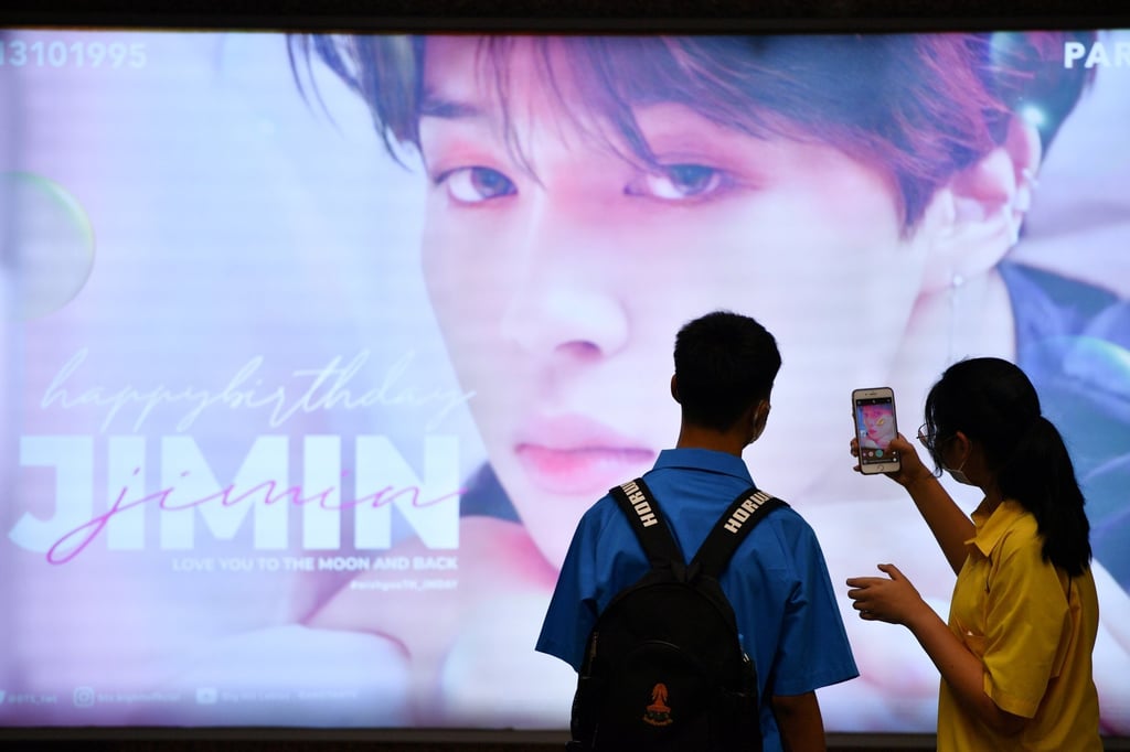 A woman takes a picture of a billboard wishing happy birthday to a K-pop singer Jimin in the subway in Bangkok, Thailand in November 2020. Photo: Reuters