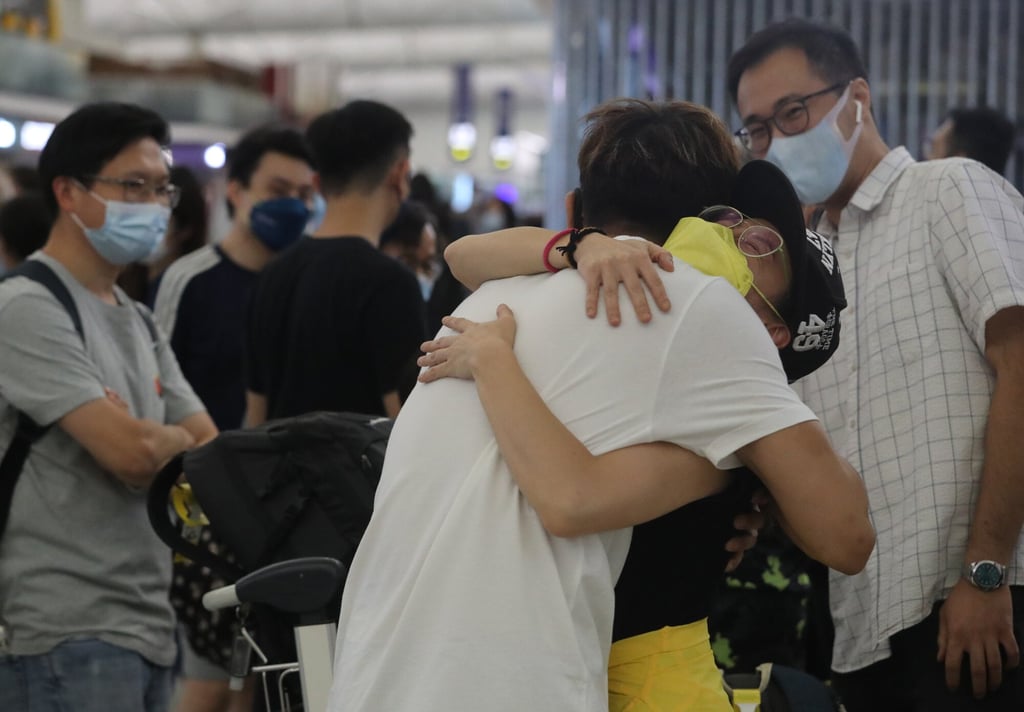 Travellers say farewell before departing for London at Hong Kong International Airport. The long queues seen daily at check-in desks for flights to the UK in particular attest to the current exodus from Hong Kong. Many of those leaving are young, often couples with children. Photo: Edmond So
