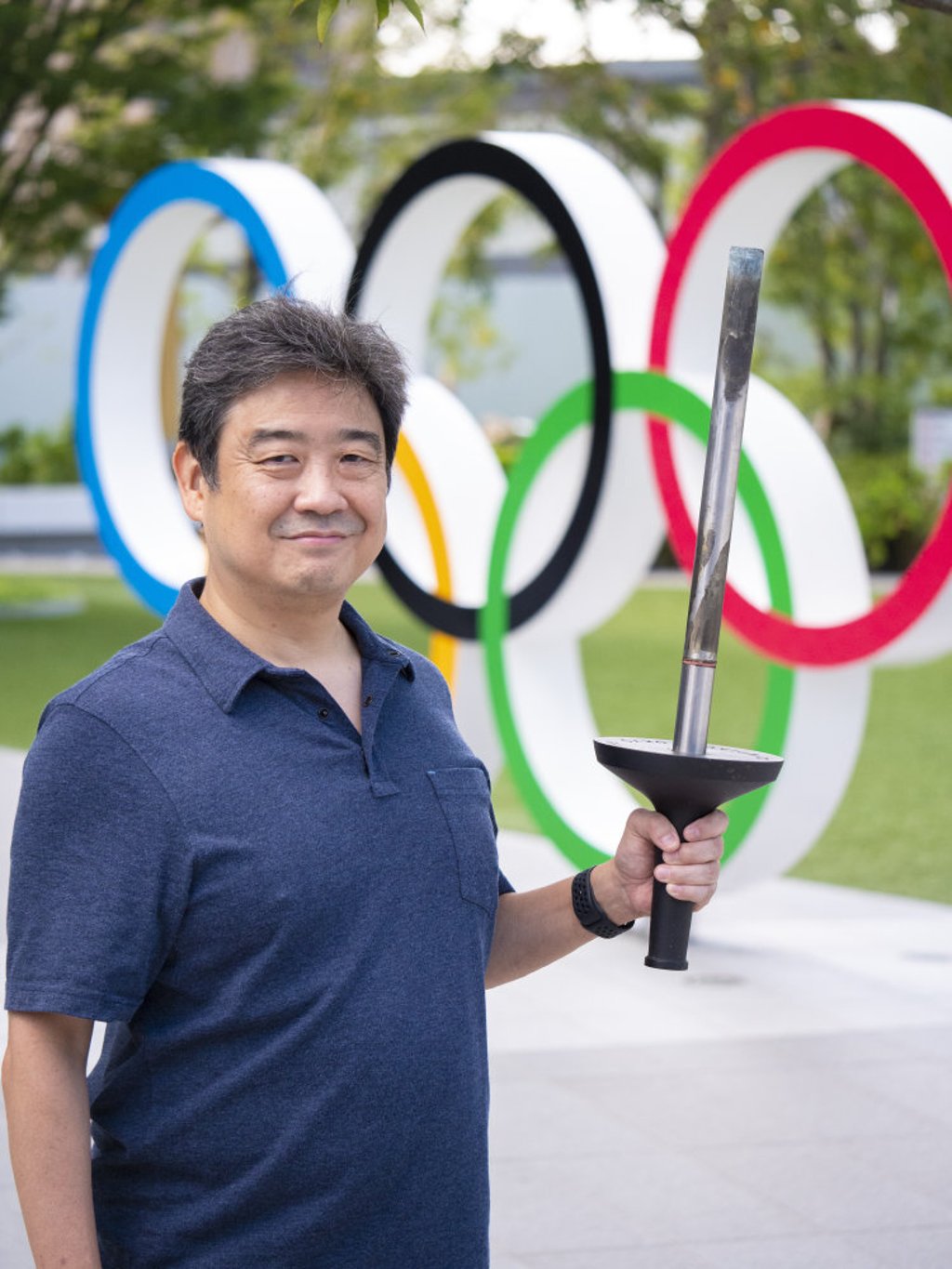 Roy Tomizawa at Japan’s National Stadium in October 2020 with an original torch from the 1964 Games. Photo: Handout Roy Tomizawa at Japan’s National Stadium in October 2020 with an original torch from the 1964 Games. Photo: Handout