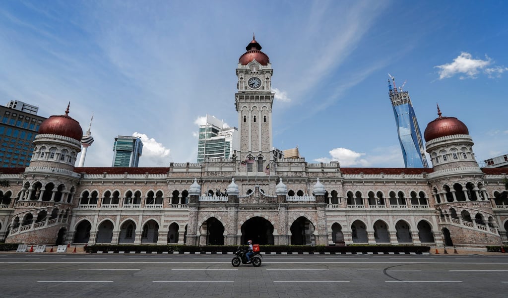 A food delivery rider in Kuala Lumpur rides in an empty street amid the lockdown. Photo: DPA