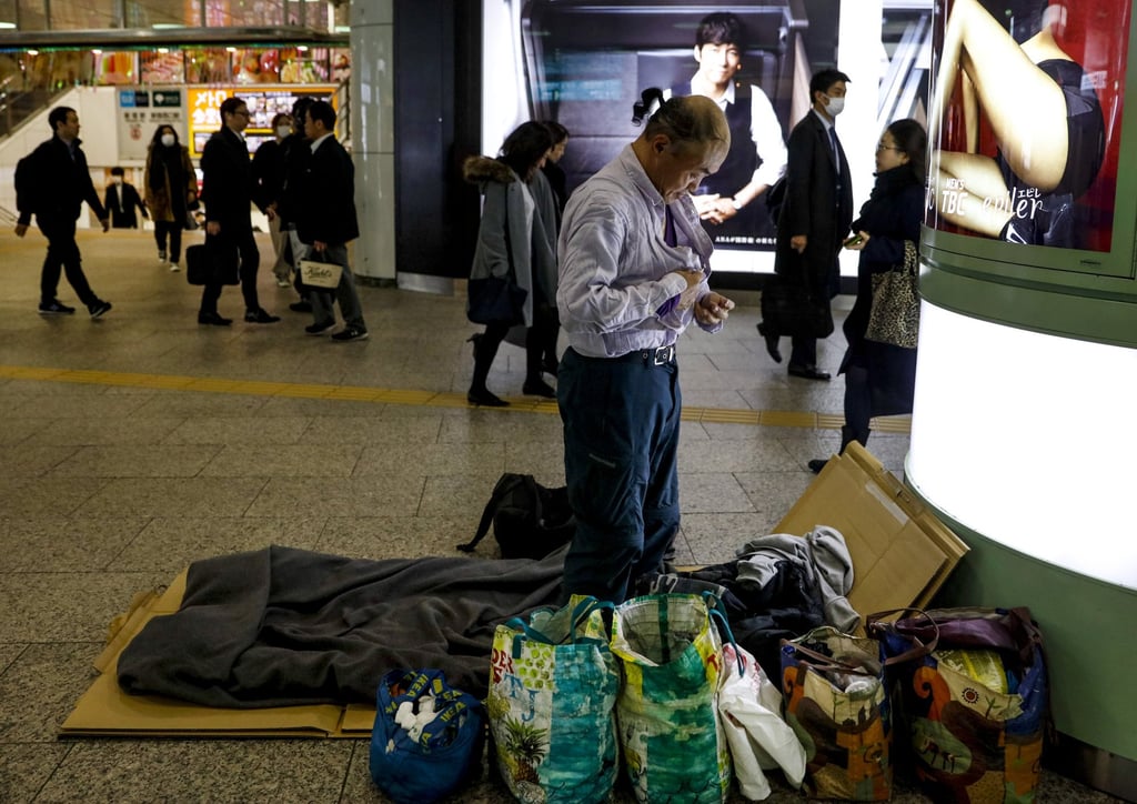 A homeless man changes into sleeping clothes at Shinjuku Station in Tokyo in January 2020. Photo: AP Hong) A homeless man changes into sleeping clothes at Shinjuku Station in Tokyo in January 2020. Photo: AP Hong)