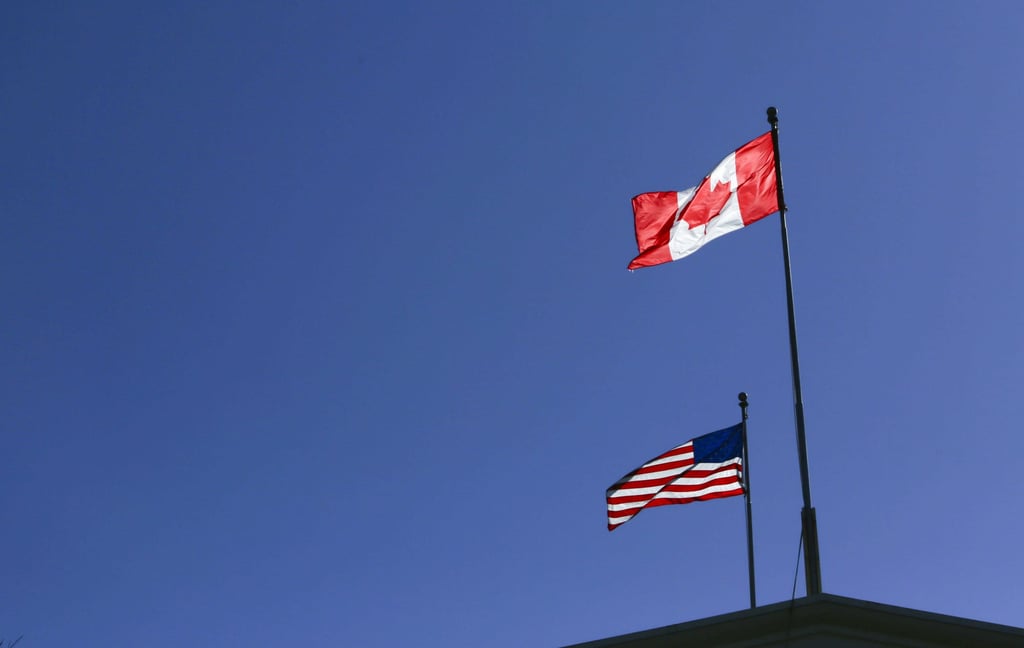 The Canadian and American flags fly above the Peace Arch Border crossing between Canada and the United States, near Seattle, Washington and Vancouver, British Columbia. Photo: Mert Alper Dervis/Anadolu Agency via Getty Images