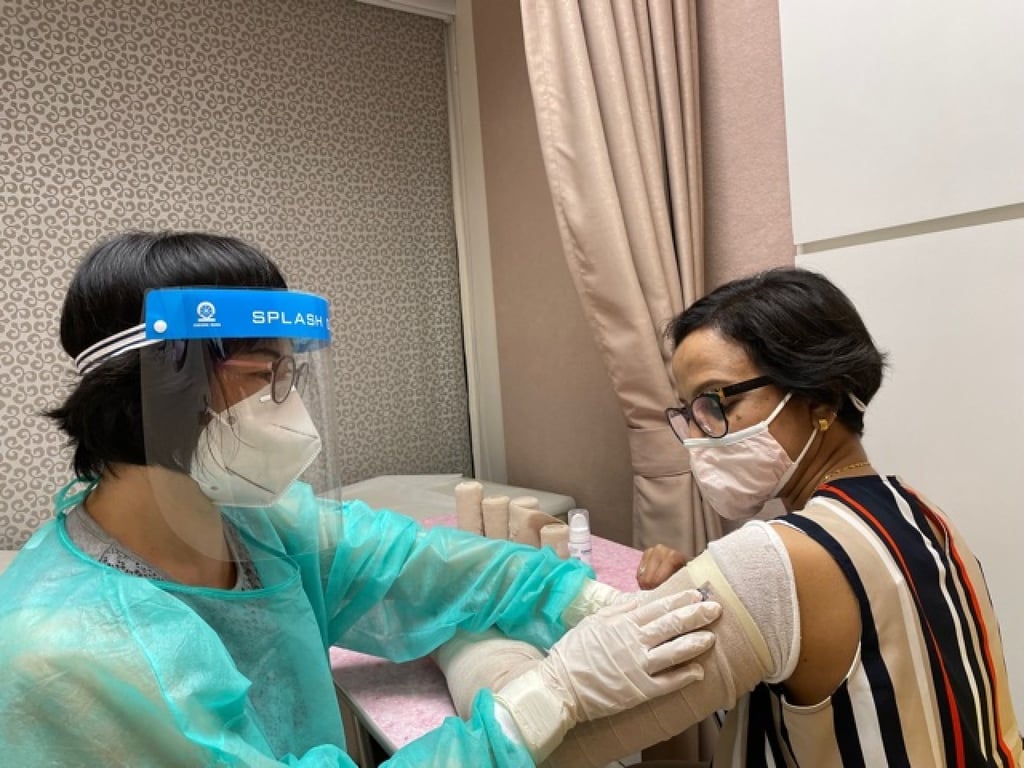 Doris Cheung, head of the Hong Kong Breast Cancer Foundation’s breast cancer support centre applies bandages to treat Niru Vishwanath’s lymphoedema. Photo: courtesy of Niru Vishwanath
