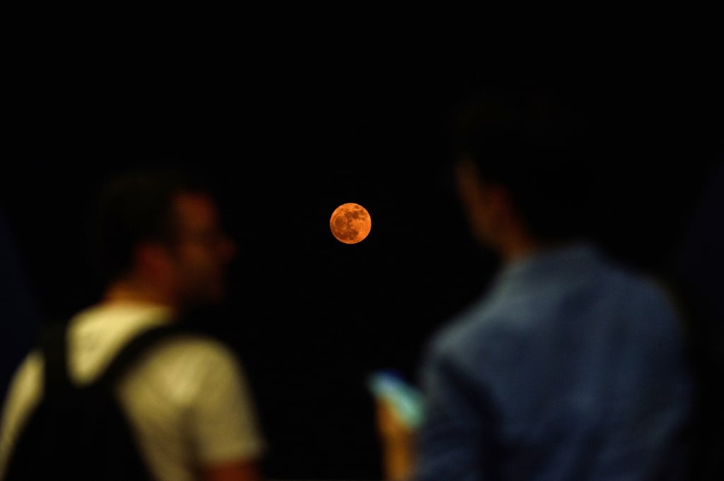 People watch as a “super moon” rises over Hong Kong in November, 2016. Photo: AFP People watch as a “super moon” rises over Hong Kong in November, 2016. Photo: AFP