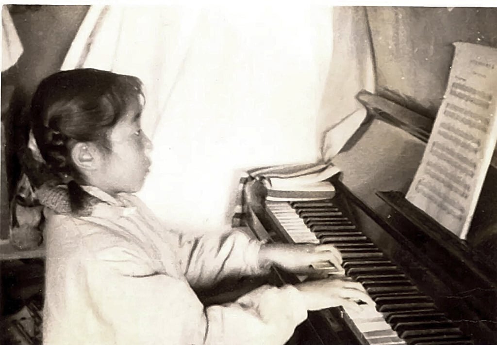 Liu playing her German upright piano on a “brick bed” in Panjin, Liaoning province, China, in 1971. Photo: Courtesy of Ying Ying Liu