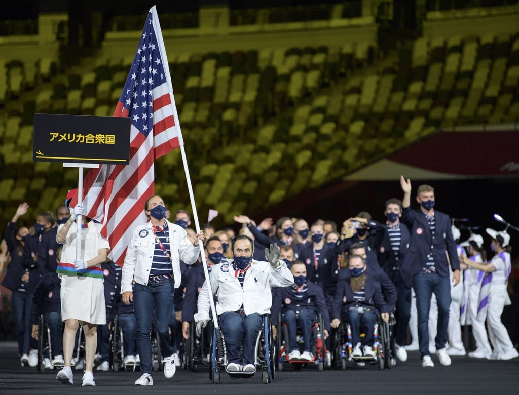 United States Paralympic team athletes Melissa Stockwell (triathlon) and Charles Aoki (wheelchair rugby) carry the flag during the Parade of Athletes at the opening ceremony of the Tokyo 2020 Paralympic Games in Tokyo, Japan on August 24. Photo: EPA-EFE