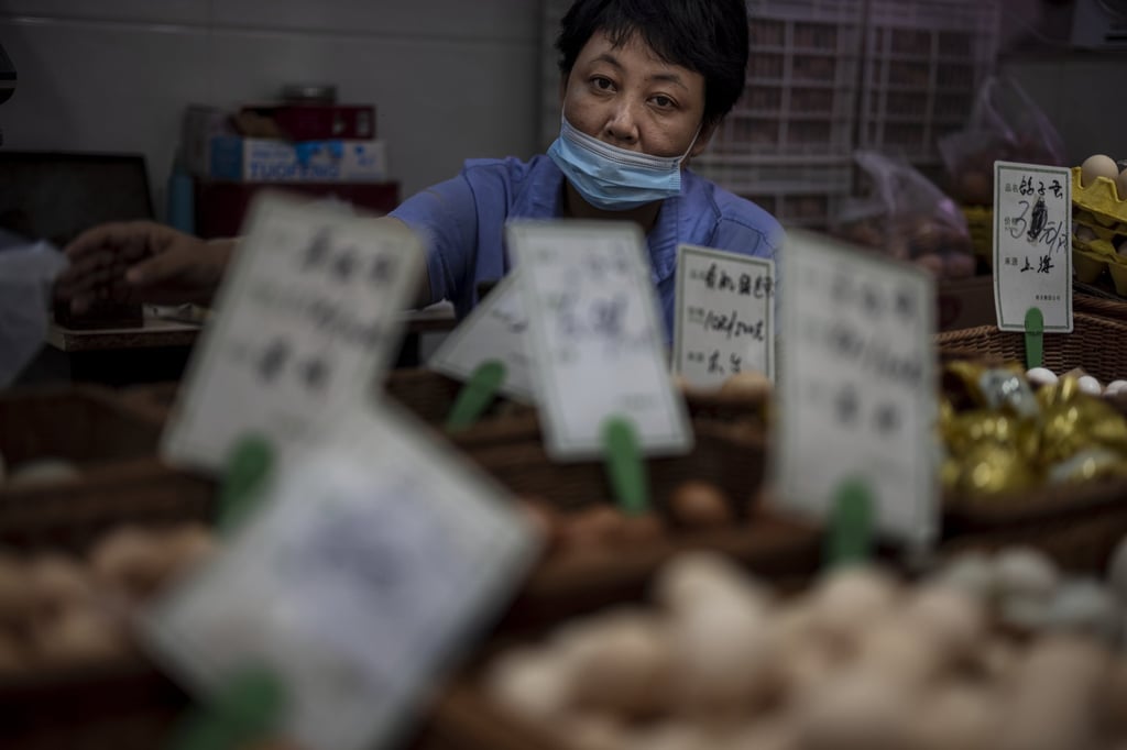 A woman sells food at a wet market in Shanghai on August 8. Chinese policymakers are mindful of the inflationary effect of any fiscal and monetary stimulus. Photo: EPA-EFE