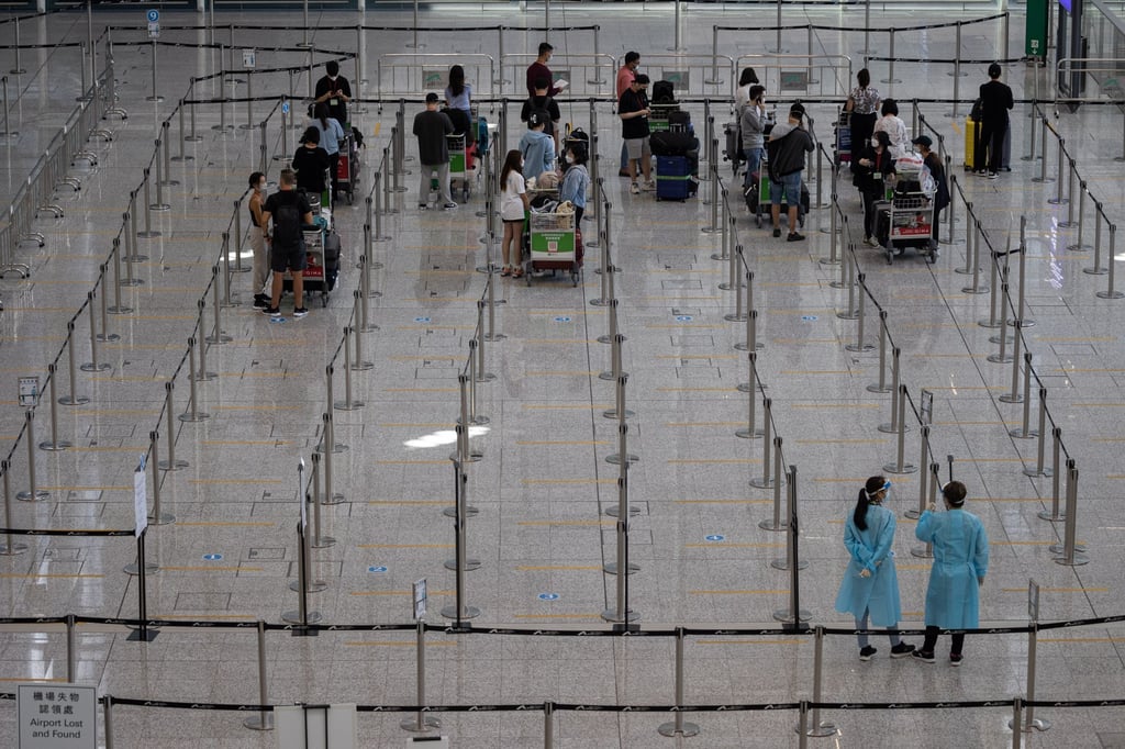 Travellers wait for shuttle buses to mandatory government-designated quarantine hotels in the arrival hall of the Hong Kong International Airport on August 17. Travel restrictions around the world have made business travel a challenge amid the pandemic. Photo: EPA-EFE