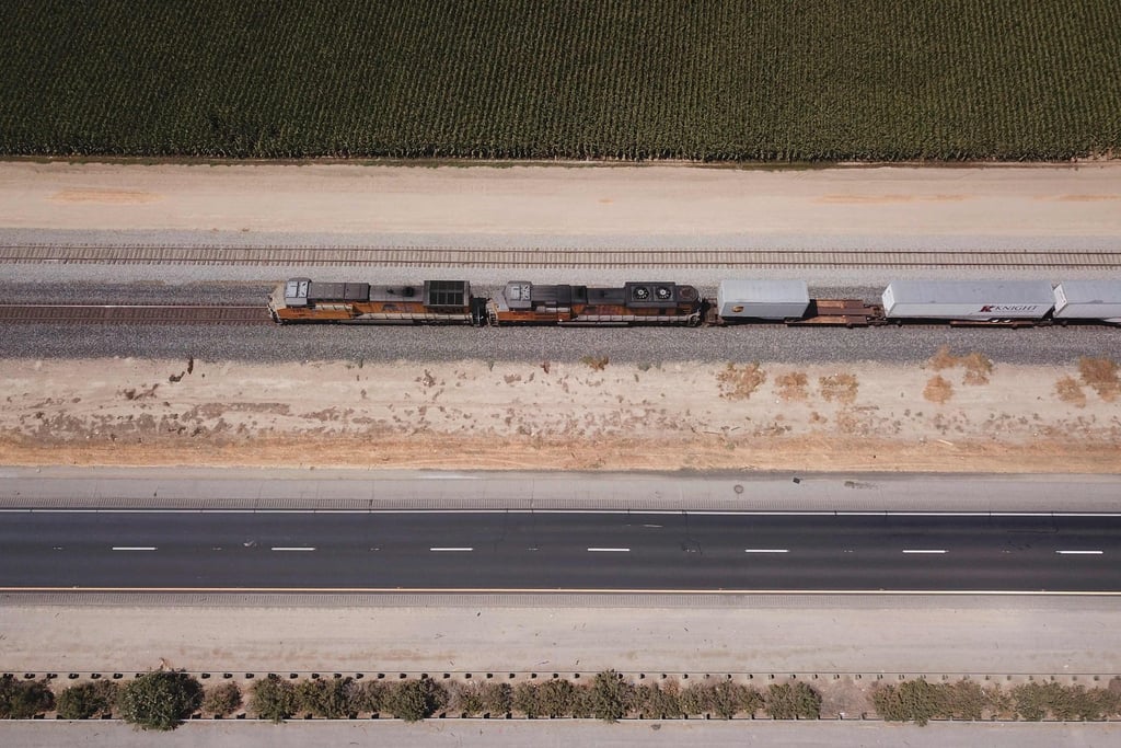 A Union Pacific Railroad freight train runs alongside US Highway 99 past farmland though Tulare county in the Central Valley, near Pixley, California, on August 26. The US Senate has passed a bipartisan infrastructure development bill that would see a US$1.2 trillion investment in roads, bridges, water pipes and high-speed internet across the United States. Photo: AFP