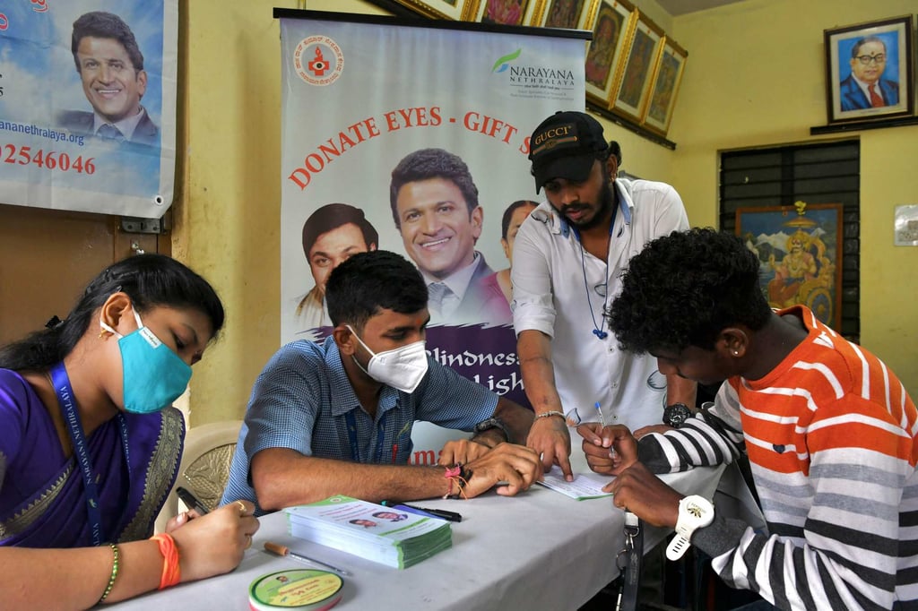 Staff at an eye hospital assist people with an eye donation pledge form on November 18, 2021. Photo: AFP Staff at an eye hospital assist people with an eye donation pledge form on November 18, 2021. Photo: AFP