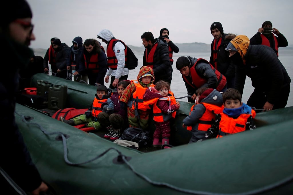 A group of more than 40 migrants with children get on an inflatable dinghy as they leave the coast of northern France to cross the English Channel on Wednesday. Photo: Reuters