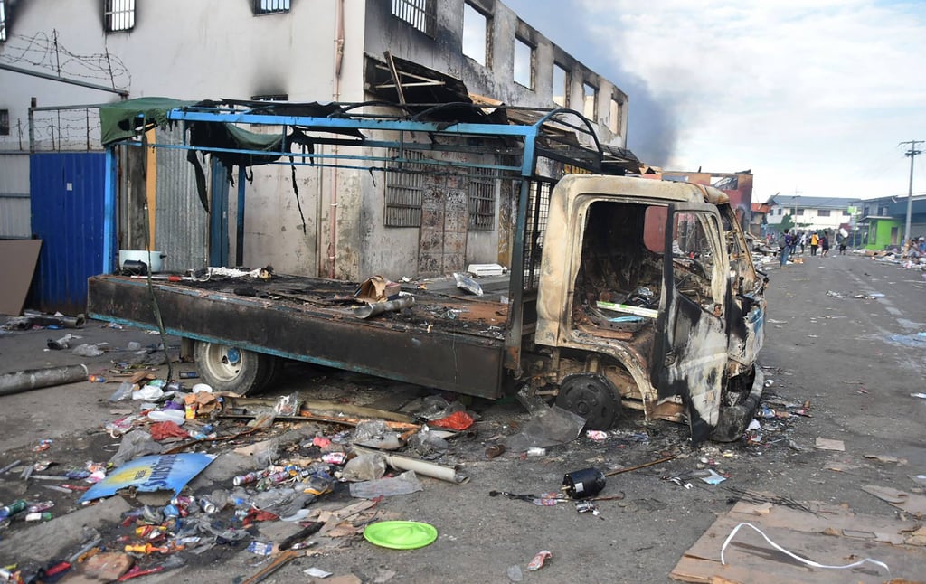 A burnt out truck sits in the Chinatown district of Honiara on the Solomon Islands on November 26, 2021, after a third day of violence that saw the prime minister’s home come under attack and swathes of the city reduced to smouldering ruins. Photo: AFP