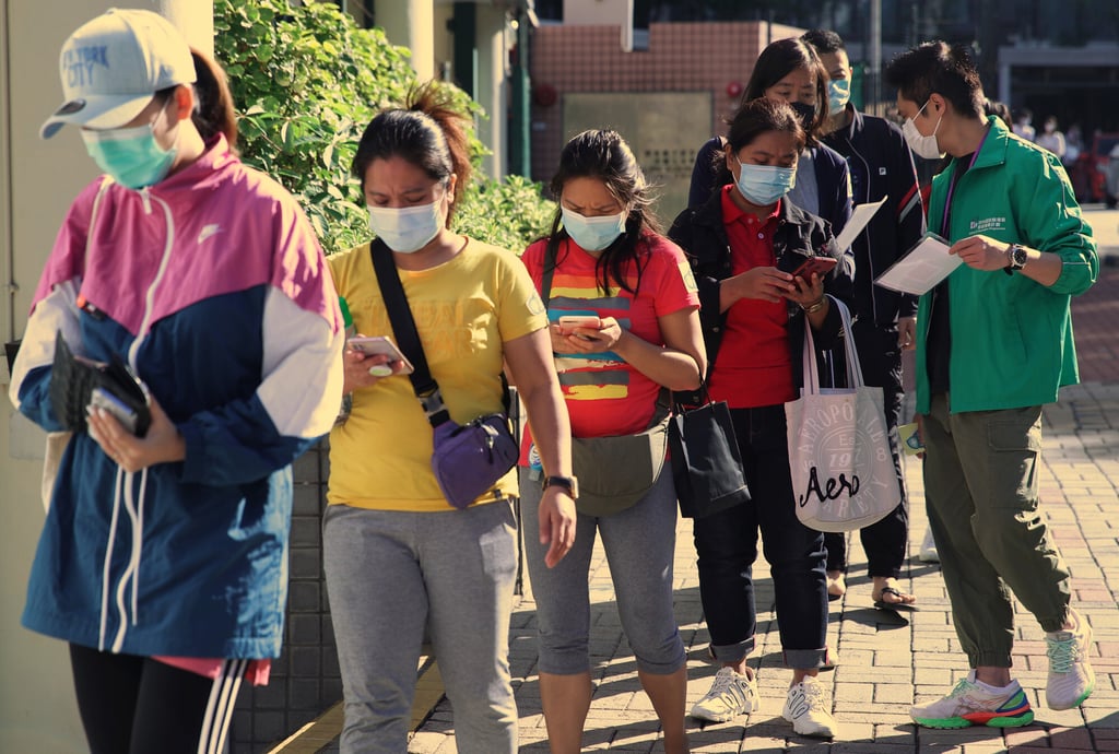 People queue to get vaccinated against the coronavirus at Ho Man Tin Sports Centre. The Hospital Authority has recommended an interval of 14 days between receiving seasonal flu and Covid-19 vaccines. Photo: Edmond So People queue to get vaccinated against the coronavirus at Ho Man Tin Sports Centre. The Hospital Authority has recommended an interval of 14 days between receiving seasonal flu and Covid-19 vaccines. Photo: Edmond So