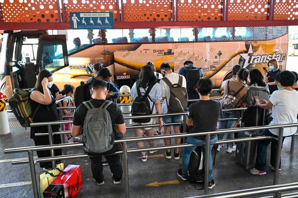 People board a bus to Johor as the land border between Singapore and Malaysia reopens on November 29, 2021. Photo: AFP People board a bus to Johor as the land border between Singapore and Malaysia reopens on November 29, 2021. Photo: AFP