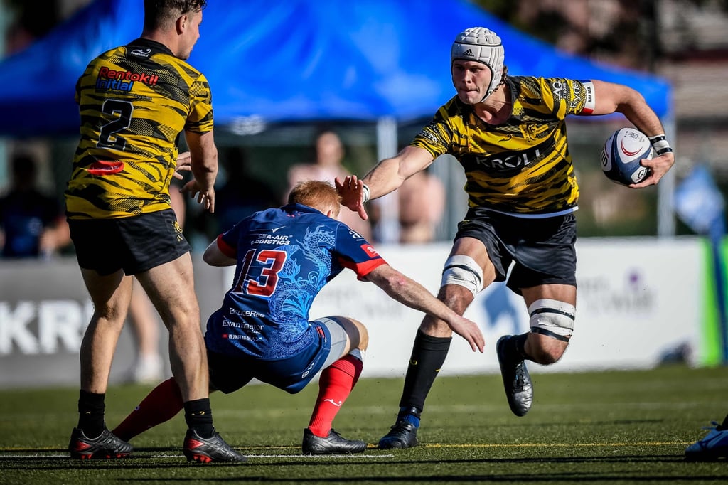 Tigers’ captain Lawrence Miller fends off Cam Smith during their Premiership clash. Photo: HKRU