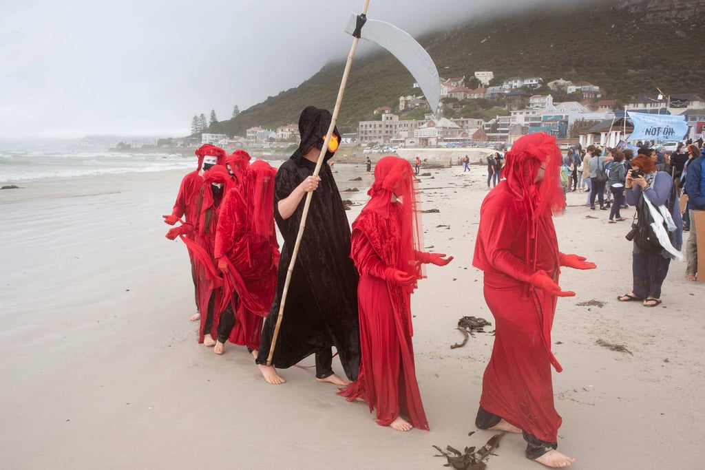 A performance group connected to Extinction Rebellion joins hundreds of others on Muizenberg Beach, Cape Town, South Africa in a protest against Dutch oil company Shell on Sunday. Photo: AFP