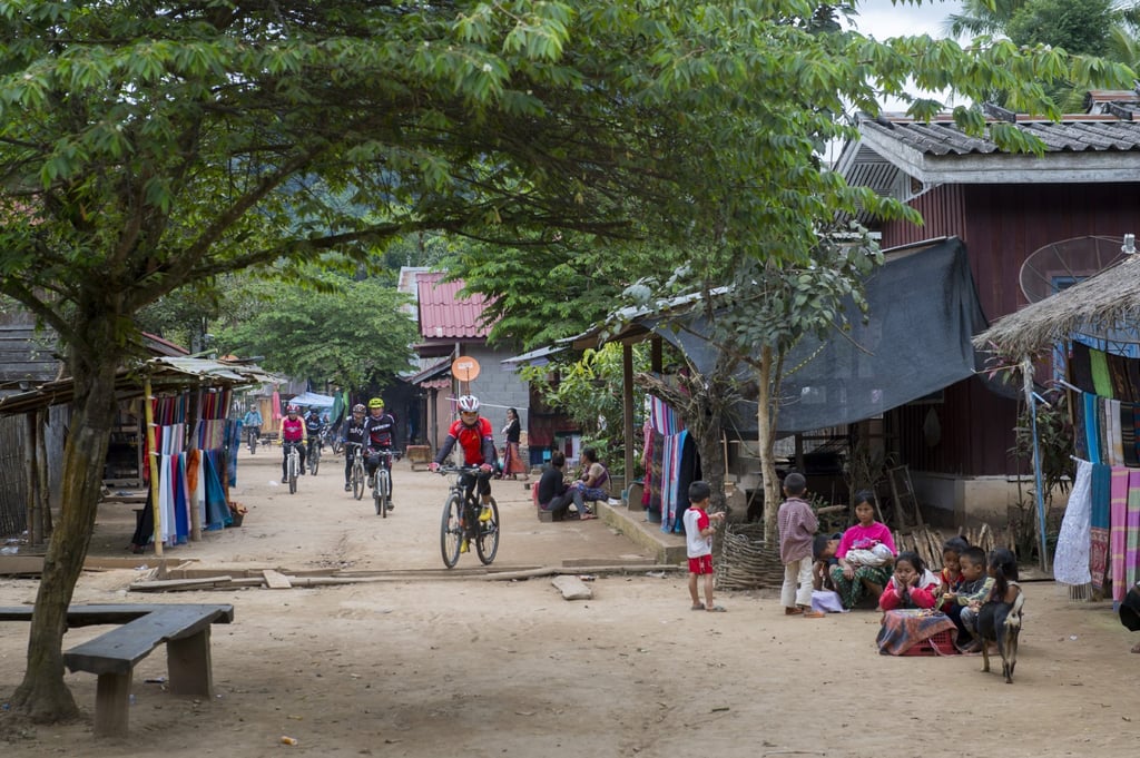 Cyclists ride through a cultural heritage village in Central Laos. The Laotian economy remains fragile, with Chinese investment so far only adding to its debt burden. Photo: Avalon/Universal Images Group via Getty Images Cyclists ride through a cultural heritage village in Central Laos. The Laotian economy remains fragile, with Chinese investment so far only adding to its debt burden. Photo: Avalon/Universal Images Group via Getty Images
