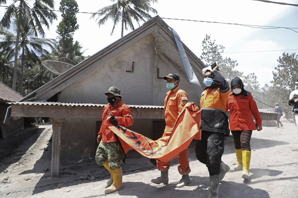 Rescuers carry a body bag containing a victim of the Mount Semaru eruption. Photo: AP