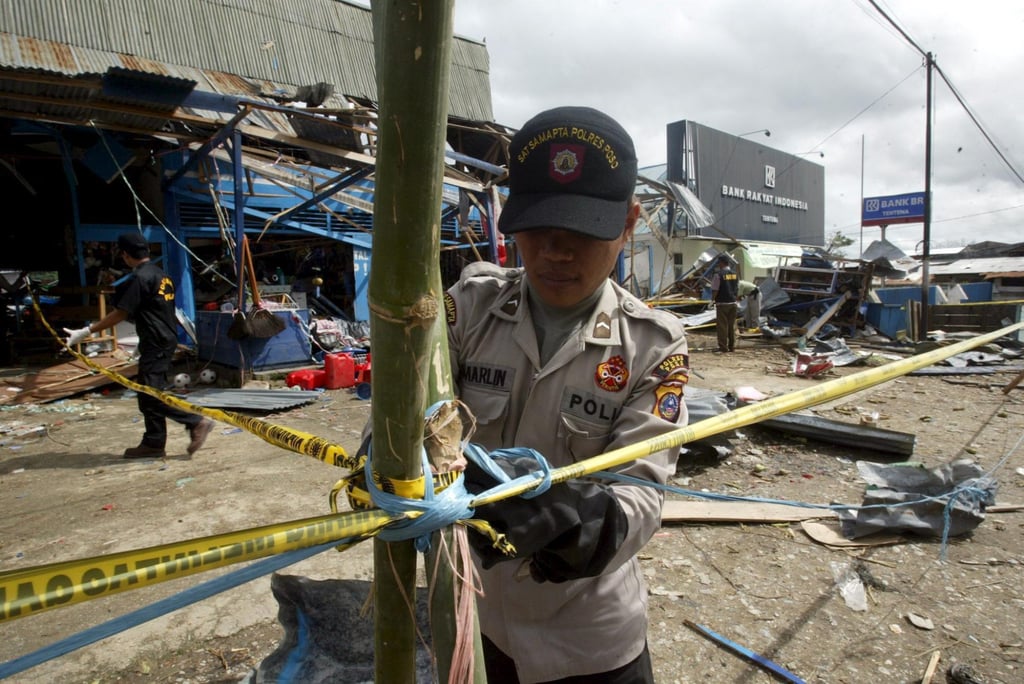 Indonesian policemen secures the bomb site at city market in Tentena, Poso, Central Sulawesi in 2005. Photo: EPA