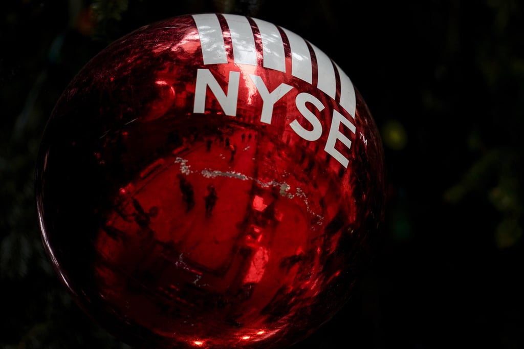 An oversized ornament is hung from a giant Christmas tree erected outside the New York Stock Exchange on November 30. The surge in global markets was primarily driven by strong corporate profits in a rebounding economy. Photo: AP An oversized ornament is hung from a giant Christmas tree erected outside the New York Stock Exchange on November 30. The surge in global markets was primarily driven by strong corporate profits in a rebounding economy. Photo: AP