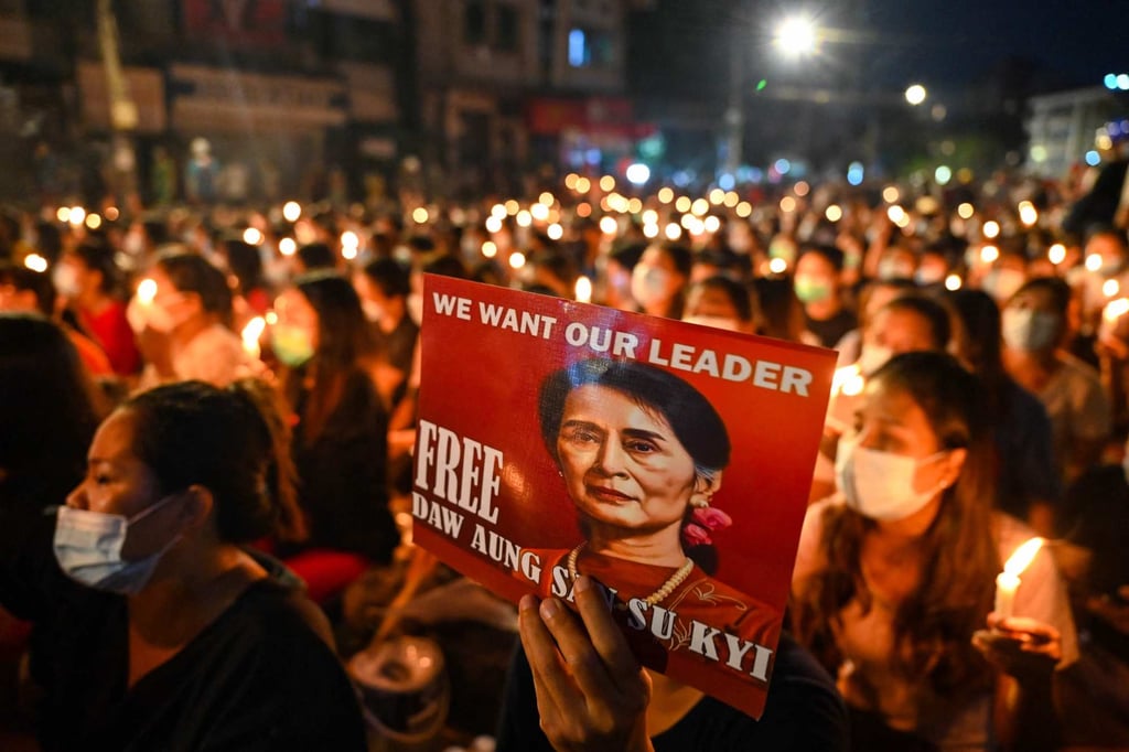 A protester in Myanmar holds a poster with an image of detained civilian leader Aung San Suu Kyi during a candlelight vigil in March 2021 to honour those who have died during demonstrations against the military coup. On December 6 the junta jailed Suu Kyi for four years for incitement and breaching Covid-19 rules, a spokesman said, the first of several possible convictions that could jail the Nobel laureate for decades. Photo: AFP A protester in Myanmar holds a poster with an image of detained civilian leader Aung San Suu Kyi during a candlelight vigil in March 2021 to honour those who have died during demonstrations against the military coup. On December 6 the junta jailed Suu Kyi for four years for incitement and breaching Covid-19 rules, a spokesman said, the first of several possible convictions that could jail the Nobel laureate for decades. Photo: AFP