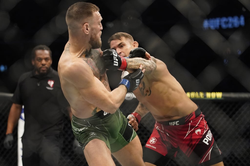 Dustin Poirier (right) punches Conor McGregor at UFC 264 in Las Vegas. Photo: AP Photo/John Locher