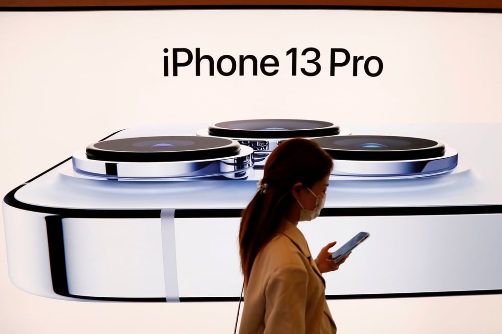 A woman wearing a face mask walks past an image of an iPhone 13 Pro at an Apple Store in Beijing in September Photo: Reuters A woman wearing a face mask walks past an image of an iPhone 13 Pro at an Apple Store in Beijing in September Photo: Reuters