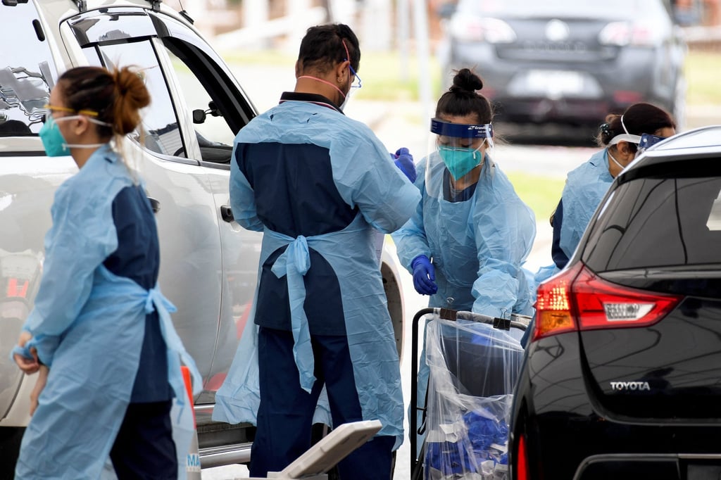 Health workers at a Covid-19 drive-through clinic in Sydney. Photo: AAP Image via Reuters