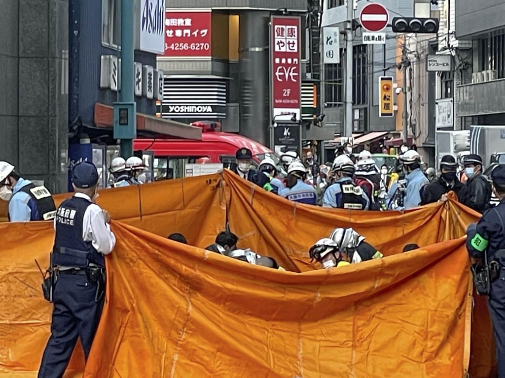 Firefighters provide first aid to those caught in the. Photo: Kyodo Firefighters provide first aid to those caught in the. Photo: Kyodo