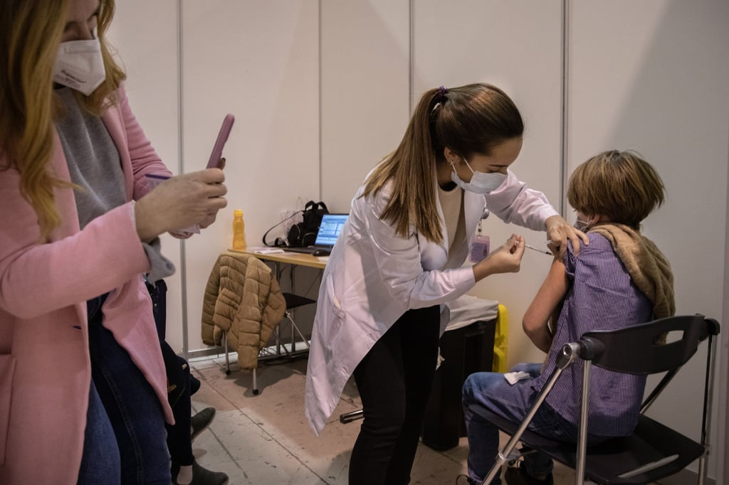 A health worker administers a Covid-19 vaccine to a child in Lisbon, Portugal, on December 19. Photo: Bloomberg