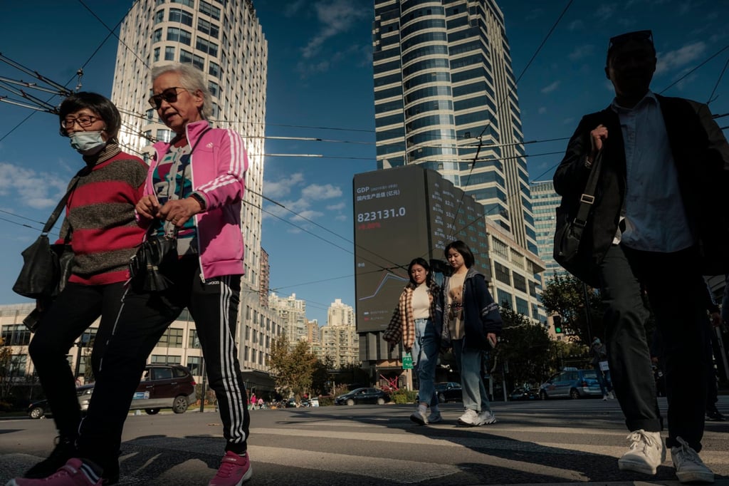 People walk on the street next to the large screen showing the latest stock prices in Shanghai. Photo: EPA-EFE