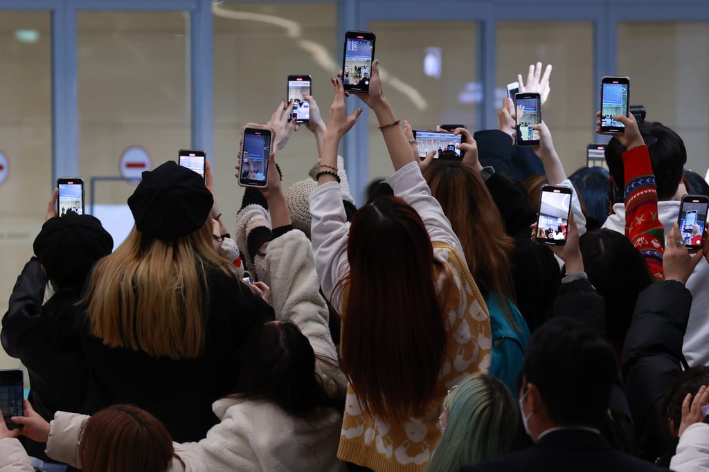 Fans take photos of South Korean boy band BTS arriving at Incheon International Airport on December 6 after a trip to the US. Photo: dpa